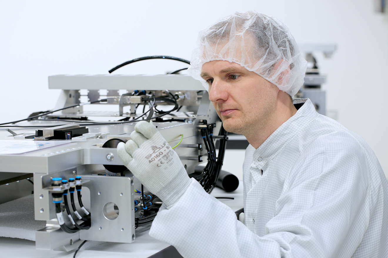 Techniker montiert Mehrachssystem im ISO-5-Reinraum