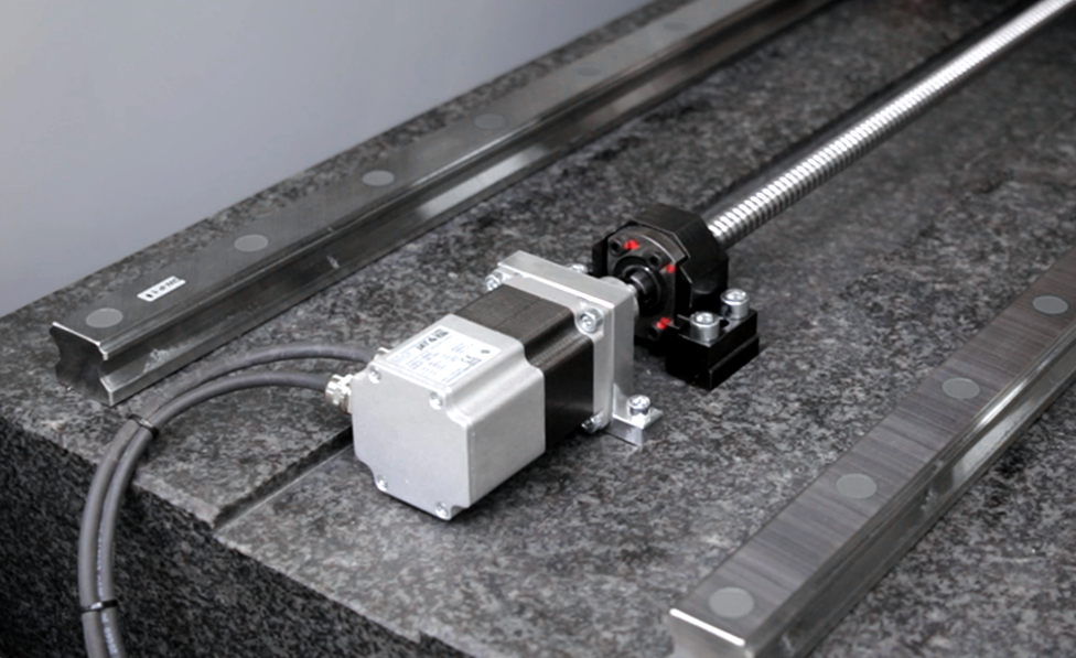 Spindle-driven linear axis with motor, guide rails and granite base
